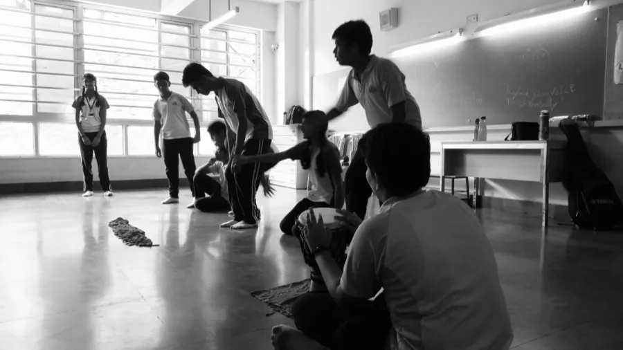 Theatre workshop in a classroom with participants seated on the floor
