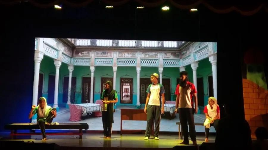 Actors on stage in front of a painted courtyard backdrop